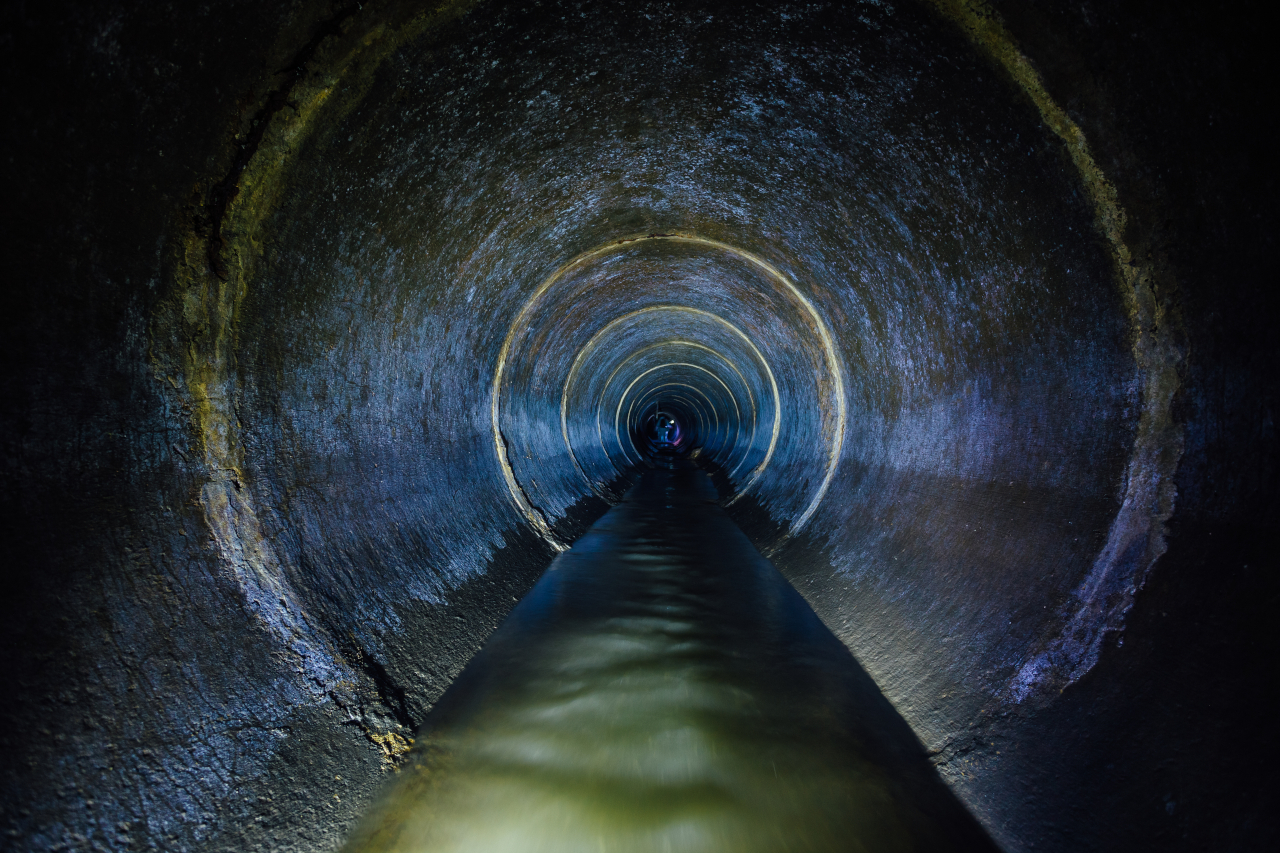 dark-underground-sewer-round-concrete-tunnel-industrial-wastewater-and-urban-sewage-flowing-throw-sewer-pipe-103719318