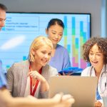 Healthcare professionals using AI data analysis to improve patient outcomes
