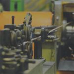 Image of factory machinery overlayed with a calculator icon to indicate a tool to improve equipment efficiency.